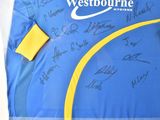 a blue and yellow shirt with a lot of autographs on it