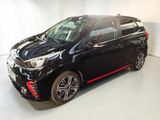 the black car is parked in a white room with a red stripe
