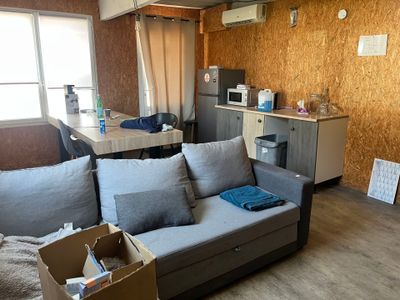un salon avec un canapé et une cuisine en arrière-plan