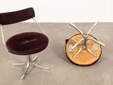 pair of chrome and velvet swivel chairs with a brown velvet seat