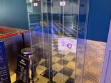 une vitrine en verre au milieu d'un sol en damier