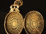 a close up of two gold lockes on a chain