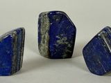 trois morceaux de lapis-lazuli sur un fond blanc