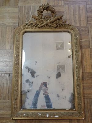 un miroir accroché au mur dans lequel on voit une personne en train de se prendre en photo