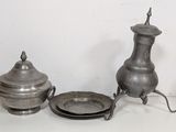 a silver plate and a silver teapot on a table