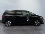 the black minivan is parked in a large room