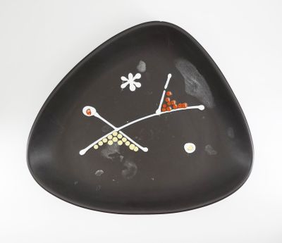 une assiette noire ornée d'un motif sur un fond blanc