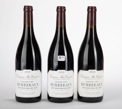trois bouteilles de vin sont alignées sur une surface blanche