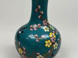 a blue vase with flowers on it sitting on a table