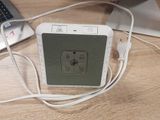 a white speaker sitting next to a laptop on a table