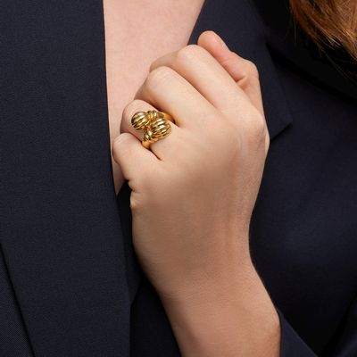 the woman is wearing a gold ring and a black blazer