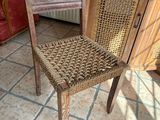 une chaise en bois avec une assise tressée, à côté d'un meuble