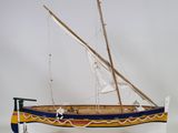 wooden model of a boat with a sail on a stand