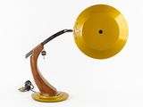 the yellow lamp is on a wooden stand with a black cord