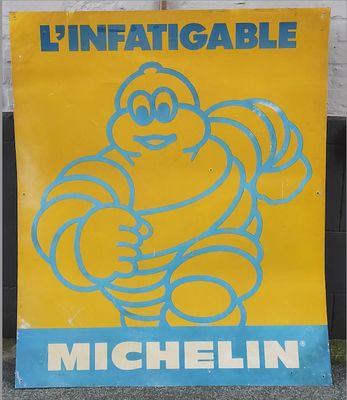 yellow and blue michel michel sign on a sidewalk in front of a brick building