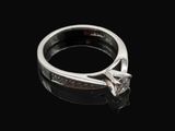 a close up of a diamond ring on a black surface