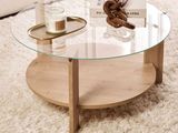 une table basse avec un plateau en verre posée sur un tapis