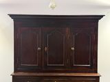 une grande armoire en bois surmontée de deux tiroirs