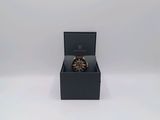 an open box with a watch inside of it on a white surface