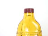 a yellow bottle with a red cap sitting on a table