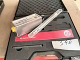 une boîte contenant un stylo et un outil, posée sur une table