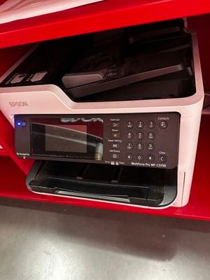 une imprimante posée sur une étagère rouge dans une pièce