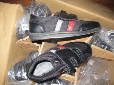 deux paires de chaussures dans une boîte posée par terre