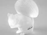 une figurine blanche représentant un écureuil avec une pelote de laine sur le dos