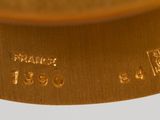 a close up of a gold clock with a pendulum on it