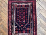un tapis rouge et bleu posé sur un plancher en bois