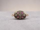 a close up of a gold ring with pink stones on it