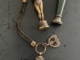 un collier avec une breloque et une bouteille posés sur une table