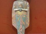 une vieille statue d'un homme avec un chapeau sur une plate-forme rouge