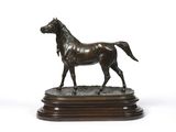 a bronze statue of a horse on a wooden base