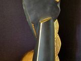 a black and gold sculpture of a woman ' s face on a black surface