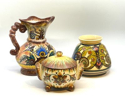 trois vases différents posés les uns à côté des autres sur une surface blanche