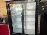 a refrigerator with two glass doors and a microwave on the counter