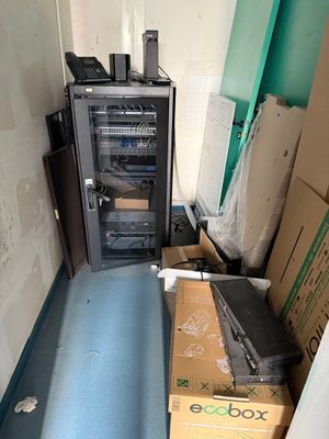 une petite pièce avec un micro-ondes et une boîte posée par terre