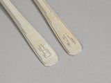 two silverware spoons and a fork on a table