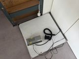 a scale that is sitting on the floor next to a stack of boxes