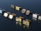 several different types of cufflinks on a black surface