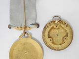 two medals and a medal on a white surface