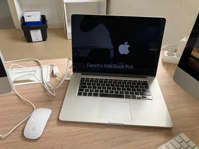 un ordinateur portable posé sur un bureau, à côté d'un écran d'ordinateur