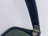 an image of a pair of black sunglasses with a green lens
