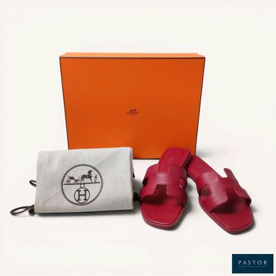 an orange box with a pair of sandals next to a pair of red sandals
