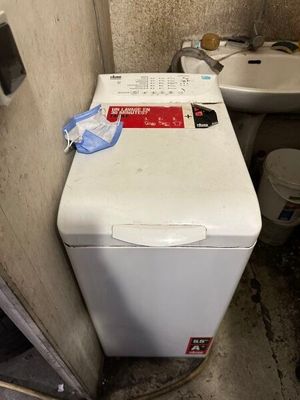 une machine à laver et des toilettes dans une petite pièce