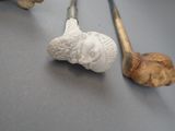 a small statue of a man holding a pipe next to a golf club