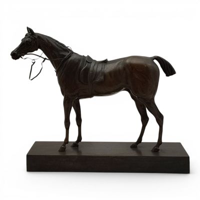 statue d'un cheval avec un mors, posée sur un socle noir