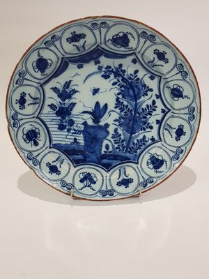 une image représentant une assiette bleue et blanche ornée d'oiseaux et de fleurs