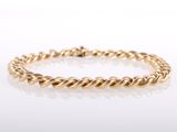 a yellow gold twisted rope bracelet on a white background